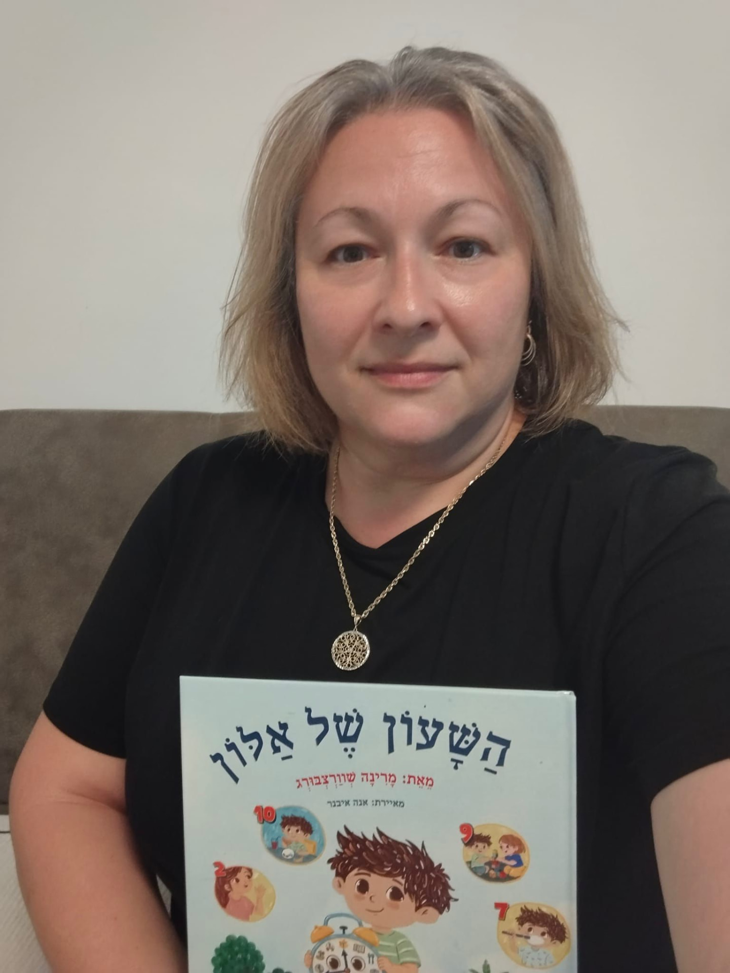 מרינה שורצבורג מחזיקה את הספר השעון של אלון